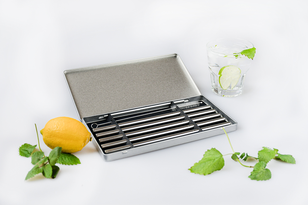 Boîte en fer blanc ouverte avec pailles en acier inoxydable, décorée avec des citrons et des herbes – ensemble de pailles élégant