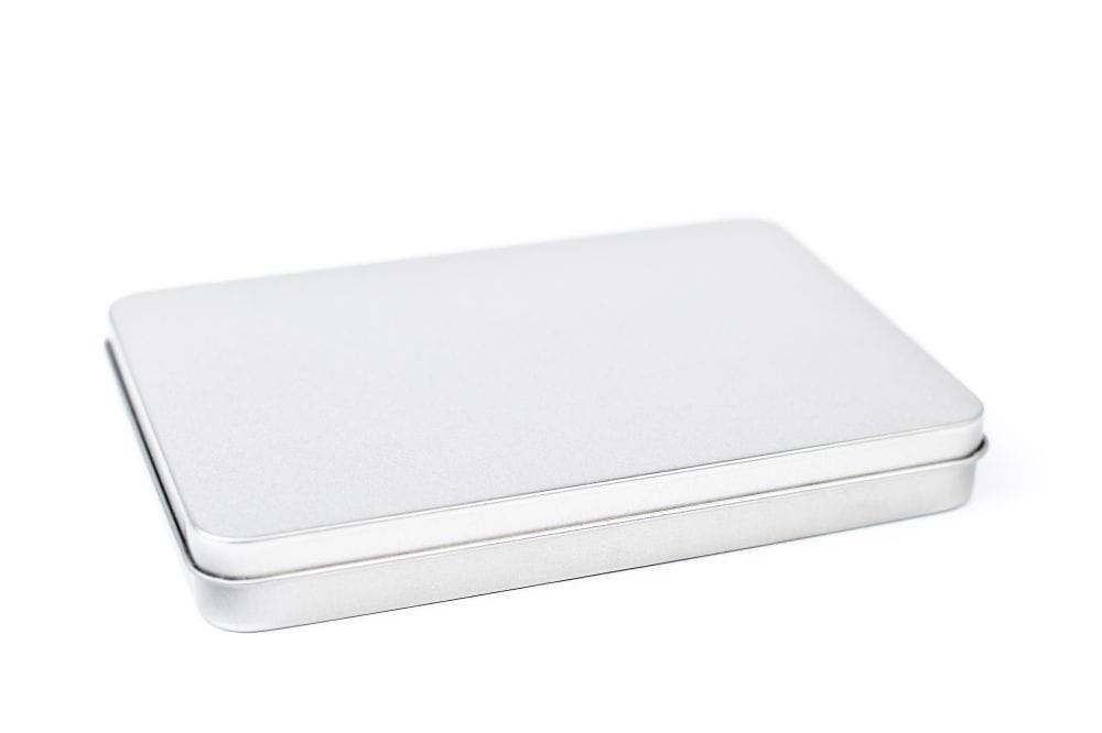 Boîte métallique rectangulaire fermée en métal argenté avec couvercle lisse, photographiée sur fond blanc.