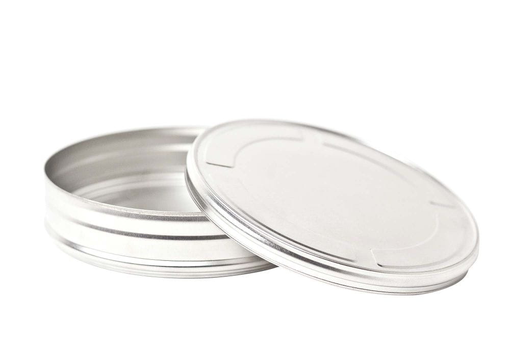 Boîte métallique ronde pour films ouverte en métal couleur argent avec couvercle retiré, photographiée sur fond blanc.
