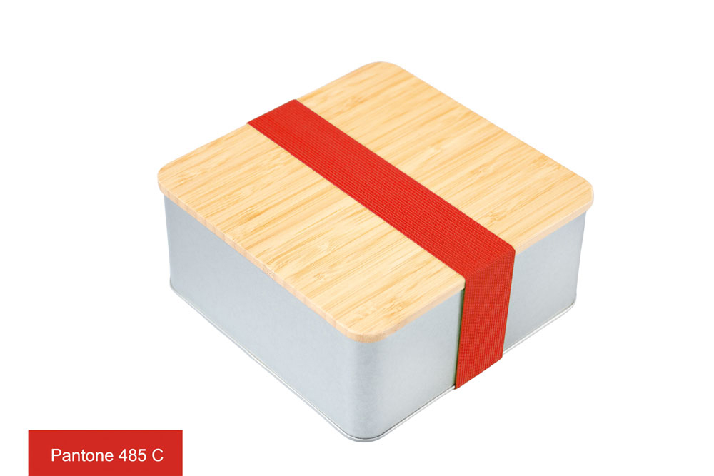 Boîte en fer blanc carrée avec couvercle en bambou et élastique rouge (Pantone 485 C) comme fermeture, photographiée sur fond blanc.