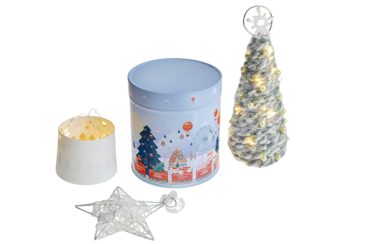 Boîte en fer blanc ronde fermée avec motif de Noël hivernal en bleu clair, représentée à côté d'accessoires de Noël décoratifsß sur fond blanc.