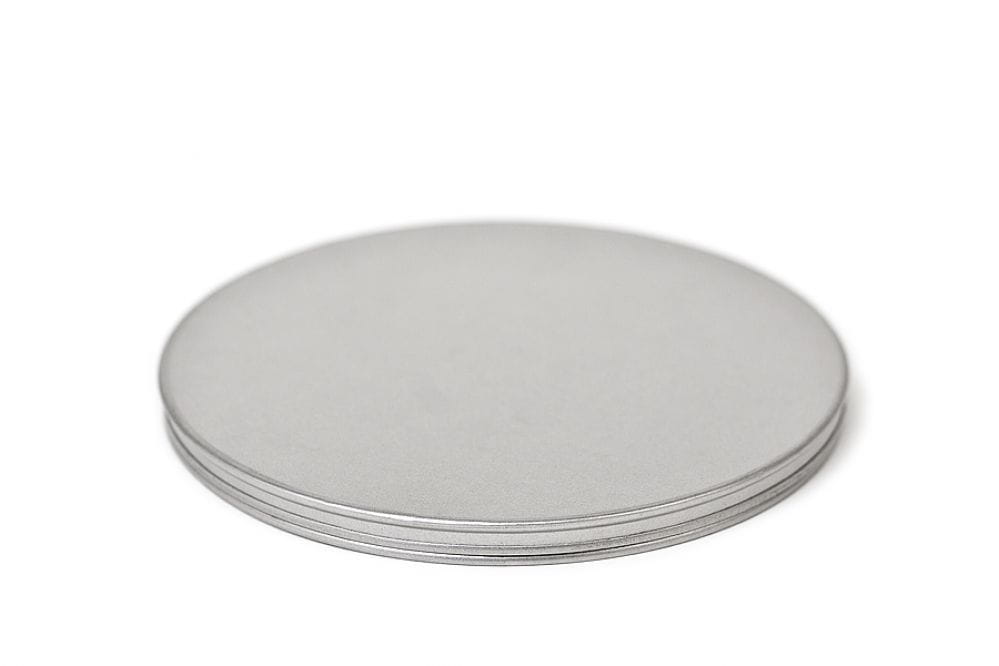 Boîte en fer blanc ronde fermée en métal couleur argent avec couvercle emboîtant, photographiée sur fond blanc.