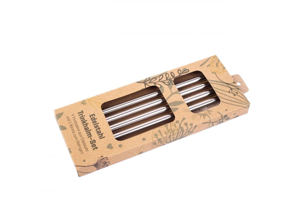 Ensemble de pailles à boire en acier inoxydable avec quatre pailles et une brosse de nettoyage dans un emballage en carton écologique, photographié sur fond blanc.