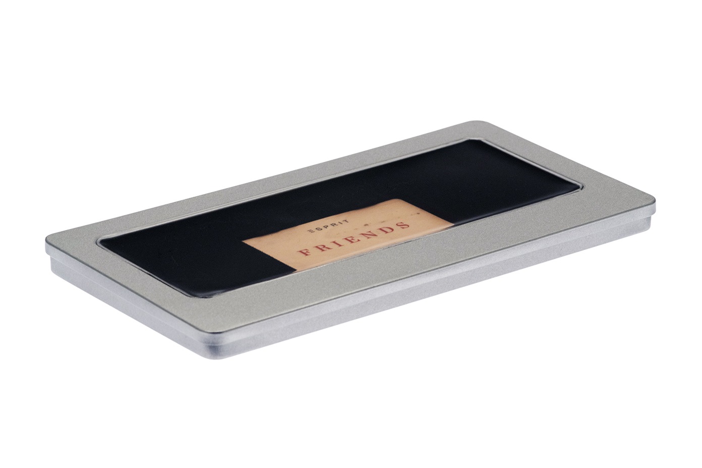 Boîte à bons-cadeaux rectangulaire fermée en métal argenté avec fenêtre de visualisation transparente sur le couvercle, intérieur avec insert noir et carte de bon-cadeau, fond neutre.
