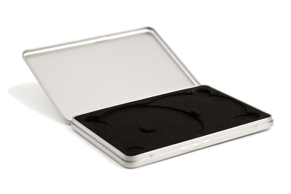 Boîte métallique DVD rectangulaire ouverte en métal de couleur argent avec plateau recouvert de velours noir pour deux DVD, photographiée sur fond blanc.