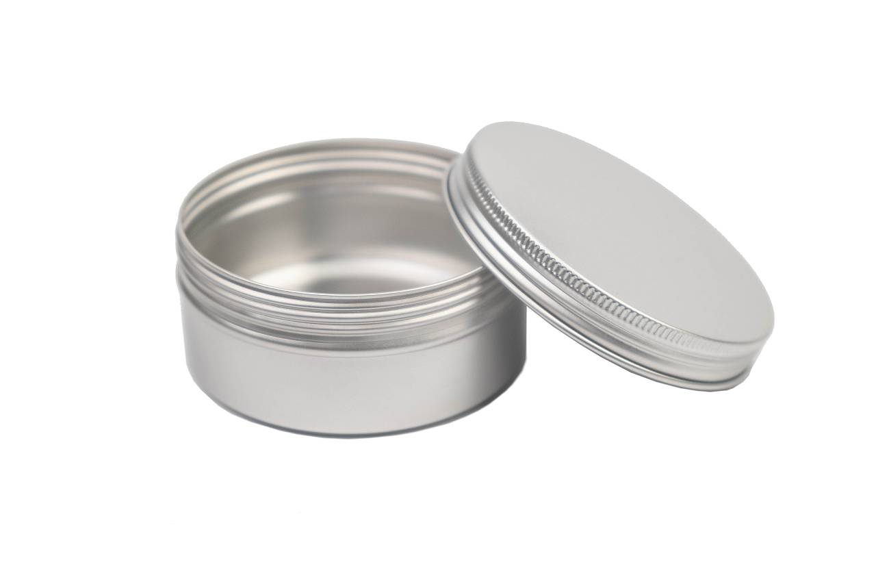 Boîte en aluminium ronde de 150 ml avec couvercle dévissé, photographiée de biais par le haut. L'intérieur de la boîte est visible.